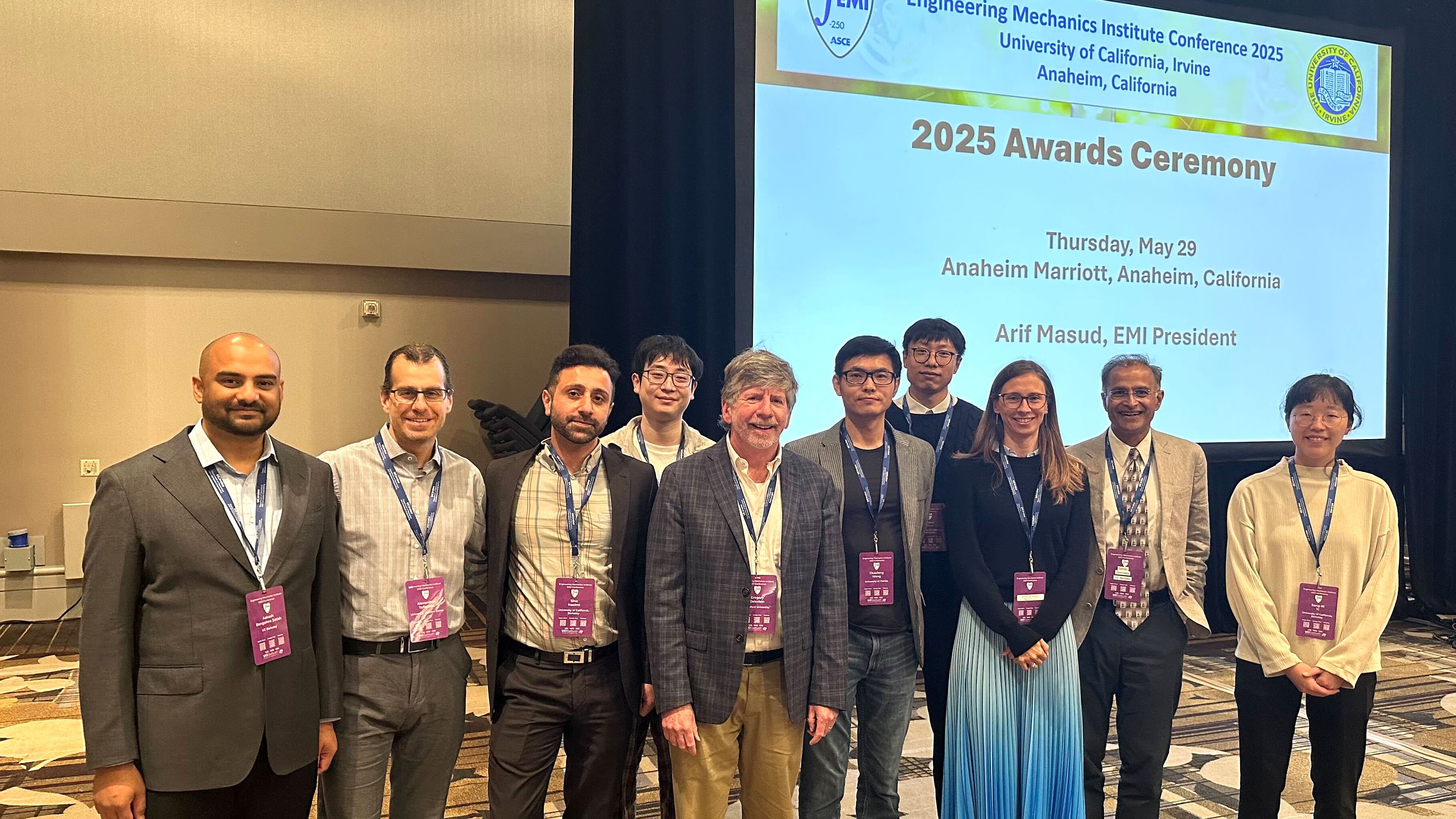 Ten researchers stand in a row and a projection screen is on the right side